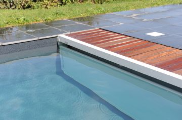 Large, modern rectangular pool with a pit-mounted slatted cover.
