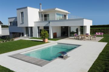 Piscine rectangulaire design enterrée avec une lame d'eau en inox.