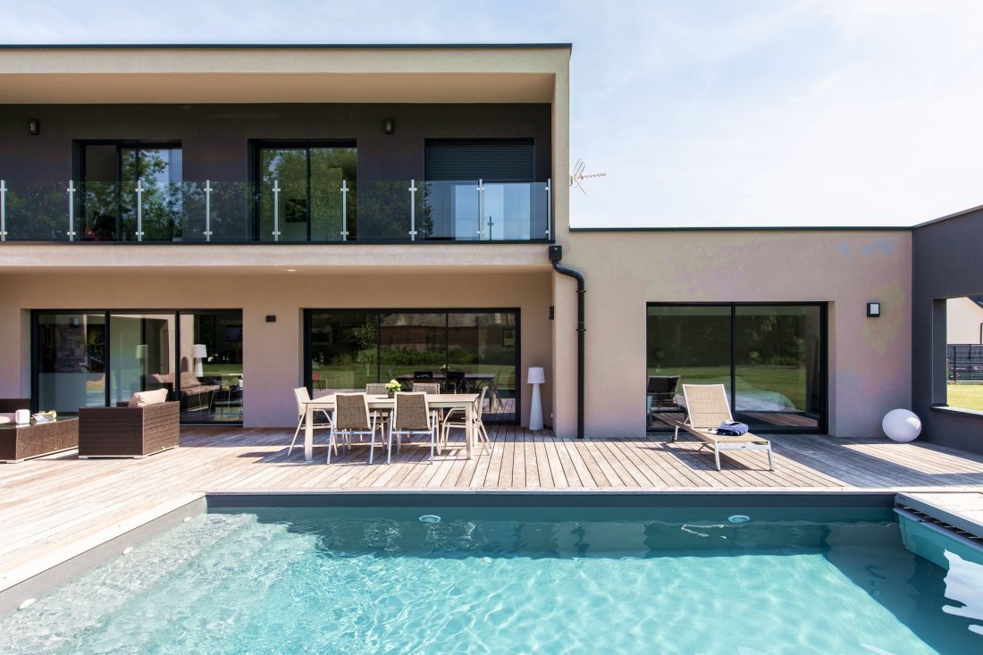 Piscine, terrasse et maison sont conçus dans une grand ensemble de lignes droites qui s’alignent et se croisent dans un vaste tableau aux couleurs pales.