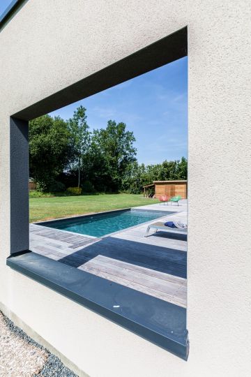 Comme une fenêtre, mais à l'extérieur. Cette ouverture dans le mur de la maison n'a qu'une vocation architecturale et offre un point de vue nouveau sur la piscine.