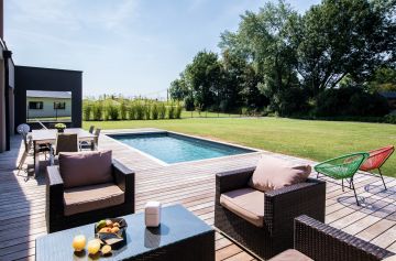 Parfaitement géré, le côté piscine de cette maison belge est une réussite esthétique totale.