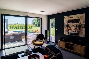 The Acapulco chairs and pool are visible through the wide patio doors in the living room, bringing a feel of holidays and faraway places to this peaceful part of the Walloon Brabant.