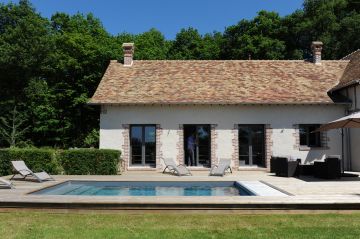 Le camaïeu de tuiles orangées, marrons et beiges du toit rénové dans la plus pure tradition normande est d'une qualité exceptionnelle et se reflète sous certains angles dans la piscine.