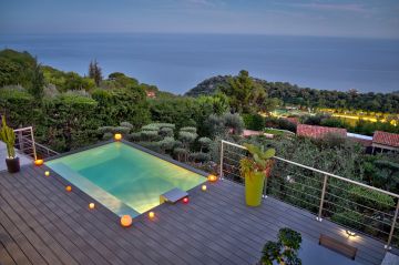 Piscinelle semi-enterrée entourée de bougies avec une vue sur la mer Méditerranée