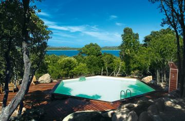 Une piscine Hx avec terrasse en bois avec une vue sur la mer 