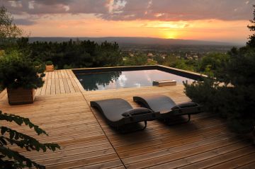 Piscine carrée Bo6 devant un coucher de soleil avec une vue imprenable sur la ville