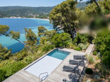 Piscine vue mer sur terrain en forte pente, terrasse bois et transats - Piscinelle