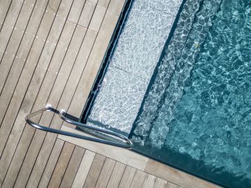 Escalier immergé et échelle inox d'une piscine sur terrasse bois - Piscinelle