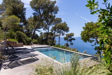 Piscine entourée de pins avec vue sur la mer - Piscinelle