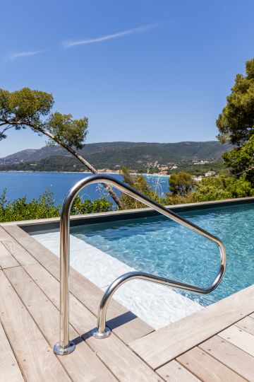 Échelle inox et vue sur la baie depuis la piscine - Piscinelle