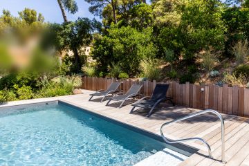 Transats sur la terrasse bois au bord de la piscine - Piscinelle