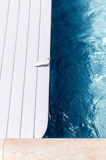 Lames de la couverture automatique sur l'eau de la piscine - Piscinelle