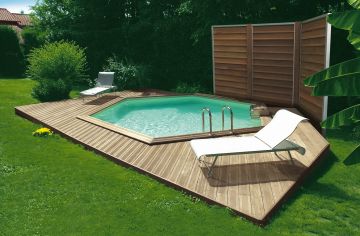 Une piscine Hx avec petite terrasse dans un jardin