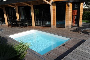 Piscine équipée d'un Rolling-Deck avec un liner blanc.