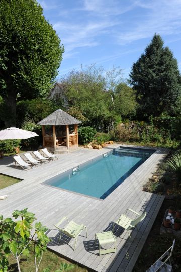 La piscine dispose d'une structure en aluminium et est équipée d'un liner gris ardoise qui lui confère un aspect de bassin intégré à l'ensemble.