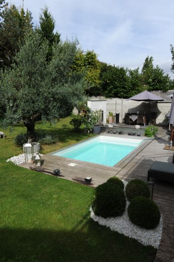 Vue d'ensemble de la piscine donnant sur le jardin d'une maison en centre ville