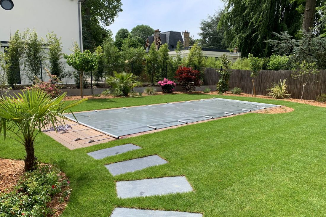 Exemple d'une Piscinelle protégée par une couverture à barres gris ardoise.