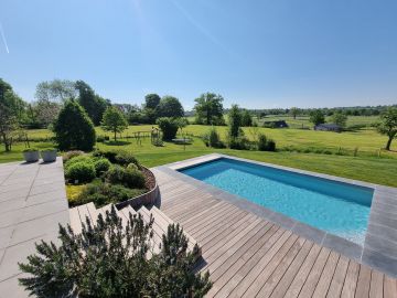 Piscinelle en Belgique avec aménagement de terrasses bois et pierre.