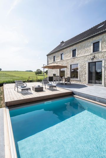 Le Rolling-Deck permet de sécuriser la piscine en un instant et s'aligne parfaitement avec la terrasse en pierre bleue qui jouxte la maison.