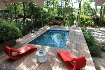 Une piscine entourée de lamelles en bois