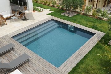 Une piscine carrée Piscinelle face à une maison moderne