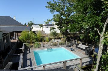 Parfaitement carrée, la piscine est installée sur une terrasse en bois