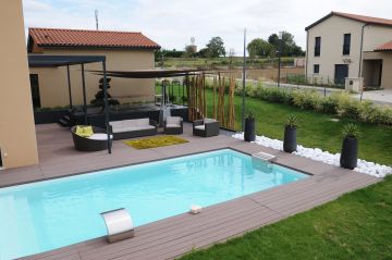 Une piscine à proximité d'un salon de jardin