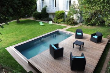 Une Piscinelle équipée d'un Rolling-Deck qui accueille du mobilier d'extérieur contemporain.